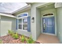 House entrance with blue door and landscaping at 4024 Tullamore Ln, Auburndale, FL 33823