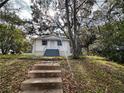 White house nestled among large trees with blue steps at 616 W Crawford St, Lakeland, FL 33805