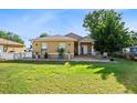 Tan house with white picket fence, landscaped yard, and spacious driveway at 2810 Jersey Rd, Winter Haven, FL 33881