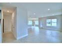 Open living room with tile floors and views into kitchen and dining areas at 1409 Leamington Ln, Winter Haven, FL 33884