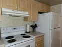 Kitchen with wood cabinets, white appliances, and a breakfast bar at 4171 Abbey Ct # 4171, Haines City, FL 33844