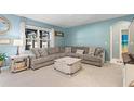 Cozy living room with a sectional sofa, a coffee table, and blue walls at 856 Sun Burst Rd, Winter Haven, FL 33880