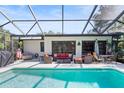 Inviting pool area with screened enclosure, lounge chairs, and dining furniture at 6168 Arborea Dr, Lake Wales, FL 33898