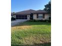 Tan single story house with brown roof and landscaping at 680 Augusta Rd, Winter Haven, FL 33884
