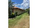 Landscaped side yard with lush greenery and a stone border at 680 Augusta Rd, Winter Haven, FL 33884