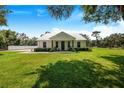 White farmhouse with metal roof and rocking chairs on porch at 12510 Lake Hatchineha Rd, Haines City, FL 33844