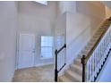 Two story entryway with tile flooring, staircase, and coat closet at 1472 Leamington Ln, Winter Haven, FL 33884