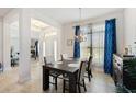 Bright dining room with a dark wood table and blue curtains at 6421 Alamanda Hills Dr, Lakeland, FL 33813