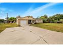 Front view of a ranch-style home with a large driveway at 329 N 19Th St, Haines City, FL 33844
