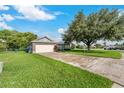 Single-story home with a large tree and long driveway at 4353 Dinner Lake Dr, Lake Wales, FL 33859