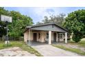 Brick home with covered porch, mature landscaping, and a basketball hoop at 2920 Gause St, Bartow, FL 33830