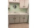 Kitchen with white cabinets and double sink at 400 El Camino Dr # 223, Winter Haven, FL 33884