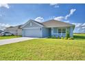 Newly built home with light gray siding, two-car garage and well-maintained lawn at 4065 Tullamore Ln, Auburndale, FL 33823