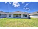 Backyard of a house with patio, grass and AC unit at 1253 Tagliamento Ln, Haines City, FL 33844