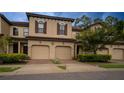 Tan three-unit townhouse with two-car garages and landscaping at 8153 Roseville Rd, Davenport, FL 33896