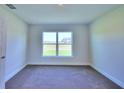 Simple bedroom with carpeted floors and a large window at 1261 Tagliamento Ln, Haines City, FL 33844