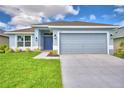 Single-story house with gray siding, two-car garage, and a manicured lawn at 502 Tanaro Ln, Haines City, FL 33844