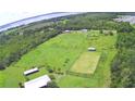 Aerial view of a large property with barns and a fenced area at 1955 W Lake Hamilton Dr, Winter Haven, FL 33881