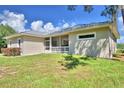 Tan house with metal roof, screened porch and grassy yard at 1955 W Lake Hamilton Dr, Winter Haven, FL 33881