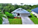 Single-story house with driveway and lush landscaping at 1001 Tequesta Trl, Lake Wales, FL 33898