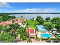 Aerial view of waterfront homes, tennis court, pool, and lush landscape at 4 Casarena Ct, Winter Haven, FL 33881