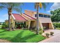 House exterior showcasing a red tile roof, lush landscaping, and a spacious lawn at 4 Casarena Ct, Winter Haven, FL 33881