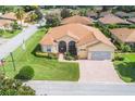 Aerial view of a tan house with a tile roof and landscaped yard at 4496 Strathmore Dr, Lake Wales, FL 33859