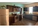 Modern kitchen featuring dark brown cabinets, stainless steel appliances, and granite countertops at 4850 St James Ct, Winter Haven, FL 33881