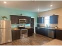 Modern kitchen featuring dark brown cabinets, stainless steel appliances, and granite countertops at 4850 St James Ct, Winter Haven, FL 33881