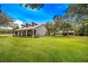 Gray farmhouse with wraparound porch and expansive yard at 8044 Lake Hatchineha Rd, Haines City, FL 33844