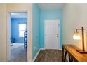 Inviting entryway with wood-look floors, leading to a bedroom and a light blue accent wall at 4850 St James Ct, Winter Haven, FL 33881