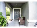Front porch with gray door and wicker chairs at 997 Pearly Ridge Ln, Lakeland, FL 33809