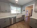 Modern kitchen with gray cabinets, farmhouse sink, and quartz countertops at 6750 Winterset Gardens Rd, Winter Haven, FL 33884