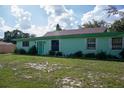 Mint green house with brown roof and green lawn at 15 Winterset Dr, Winter Haven, FL 33884