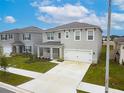 Two-story house with gray siding, two-car garage, and front yard at 460 Boardwalk Ave, Haines City, FL 33844