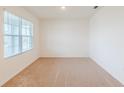 Simple bedroom with carpeted floor and window with blinds at 460 Boardwalk Ave, Haines City, FL 33844