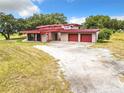 Ranch-style home with red metal roof and attached garage at 2741 Edwards Rd, Haines City, FL 33844