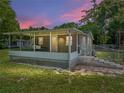 A cozy house with a screened porch, at dusk at 14813 Camp Mack Rd, Lake Wales, FL 33898