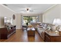 Inviting living room with plush sectional sofa, wood floors, and sliding glass doors to the backyard at 1521 Oakview Se Cir, Winter Haven, FL 33880