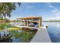 Covered boat lift with two boat slips and a dock at 121 E Lake Summit Dr, Winter Haven, FL 33884