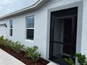 Front view of a house with a covered entryway and landscaping at 177 Cimarron Ln, Kissimmee, FL 34759