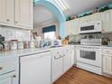 White kitchen with appliances, ample counter space, and wood flooring at 716 Challenger Ave, Davenport, FL 33897