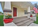 Front porch with red door, flower pots, and American flag at 816 W Hancock St, Lakeland, FL 33803
