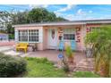 Pink house with a front porch, yellow bench, and teal chairs at 512 N 4Th St, Haines City, FL 33844