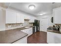 Kitchen with white cabinets, dark countertops, and black appliances at 3050 Cross Fox Dr, Mulberry, FL 33860