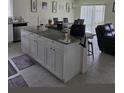 Kitchen island with granite countertops and white cabinets at 1036 Mattie Pointe Way, Auburndale, FL 33823