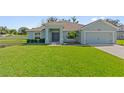 Light blue single-story house with a two-car garage and manicured lawn at 230 Cove At Eagle Lake Cir, Eagle Lake, FL 33839