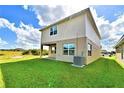 Tan two-story house with a spacious backyard at 1480 Leamington Lane, Winter Haven, FL 33884