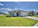 Single-story home with a two-car garage and well-manicured lawn at 1560 Leamington Lane, Winter Haven, FL 33884