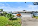 Well-maintained house with a two-car garage and manicured lawn at 1437 Grand Cayman Cir, Winter Haven, FL 33884